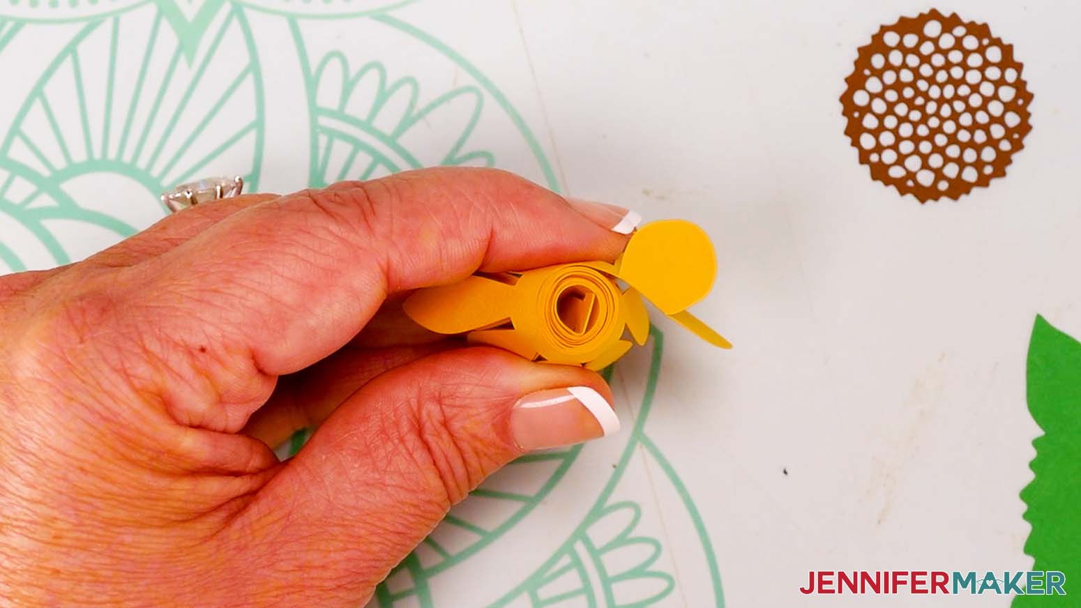 Add hot glue to the bottom circle and press it against the bottom of the flower to secure it.