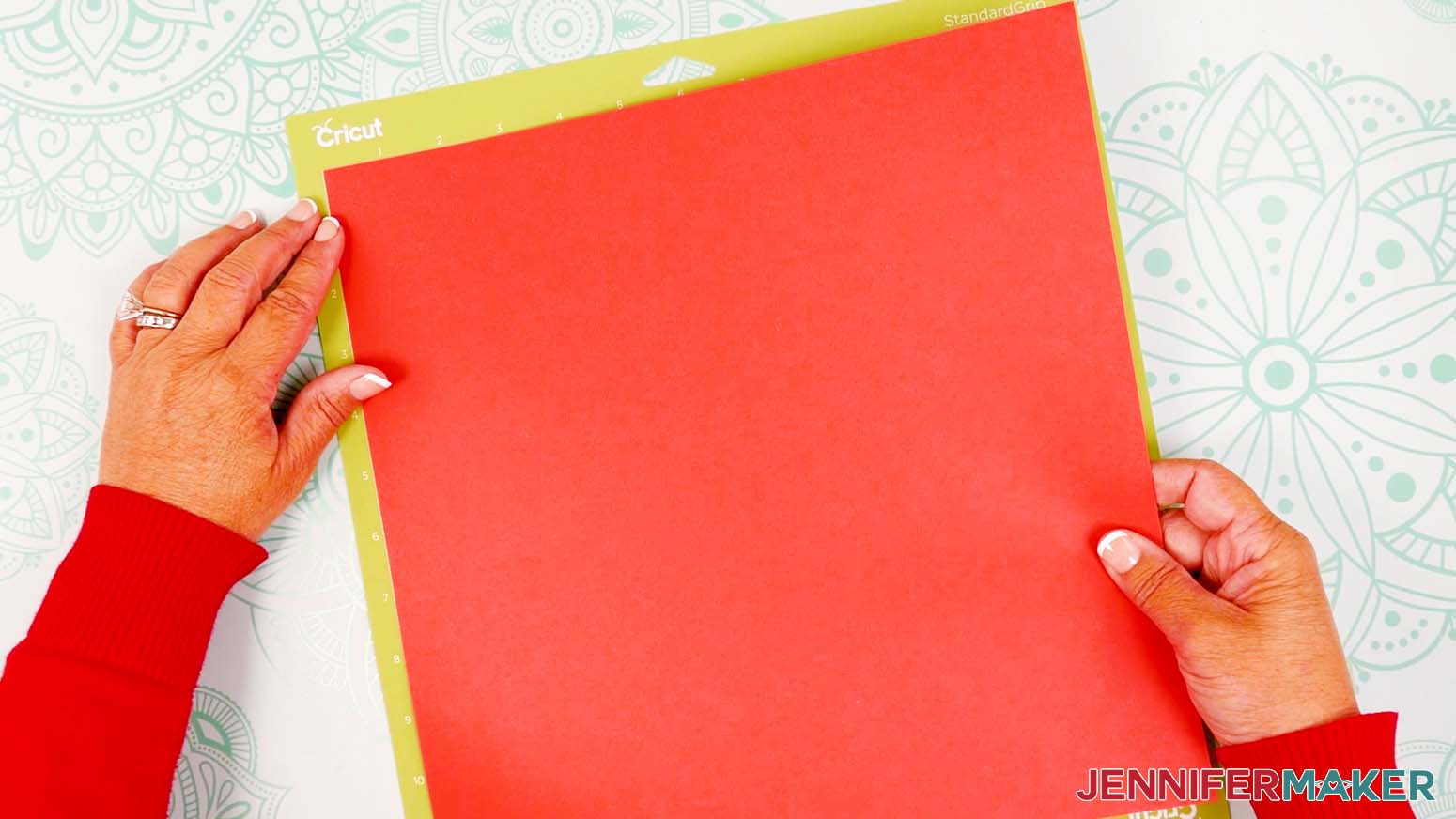 Place the first piece of red cardstock on a green machine mat.