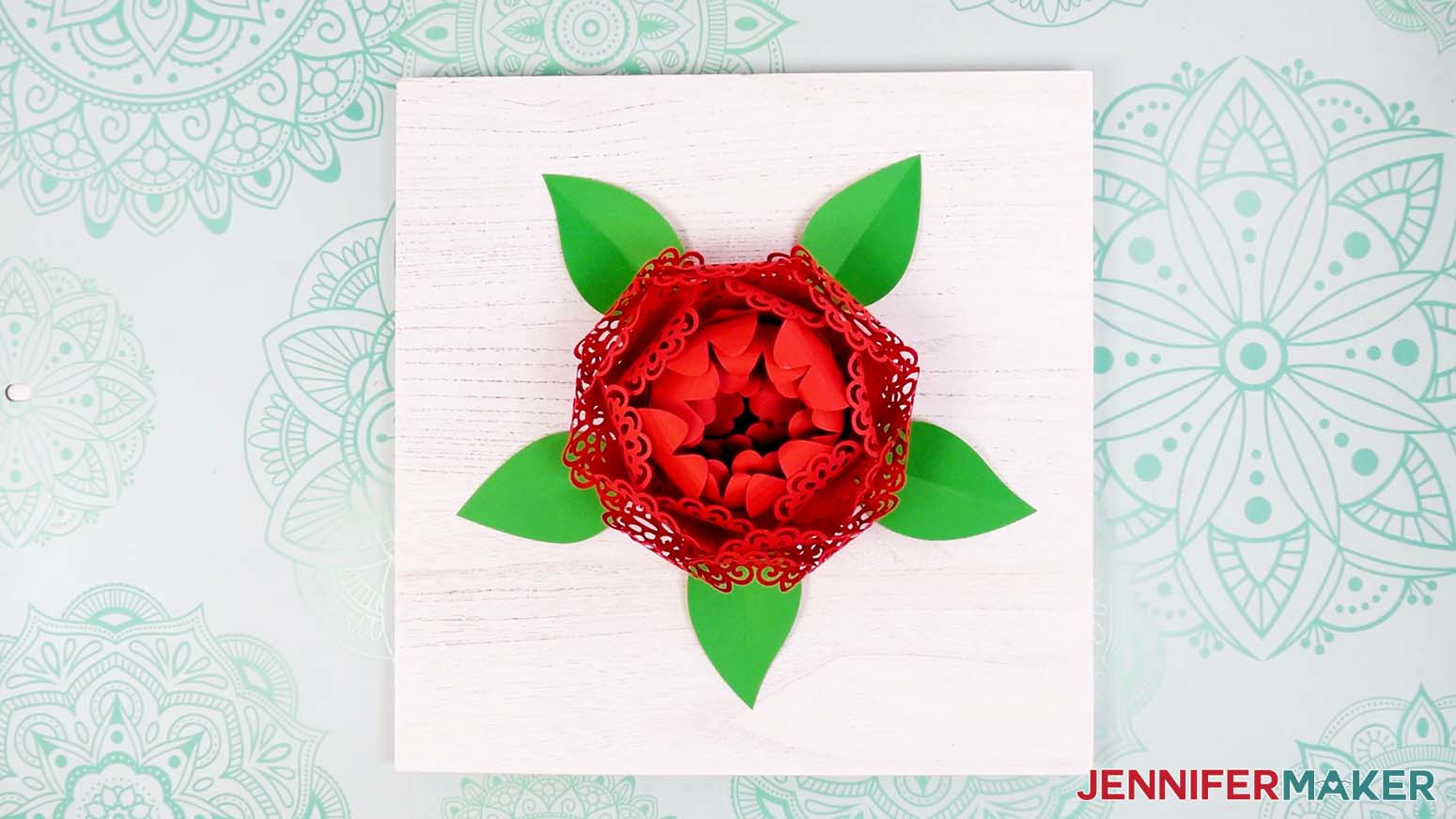 Arrange the leaves around the finished lacy flower on the wood panel.