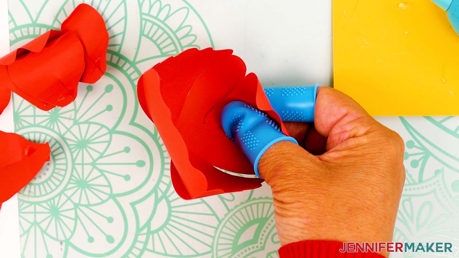Place the petal’s glued tab halfway down the inside of one of the bud bowl’s sides.