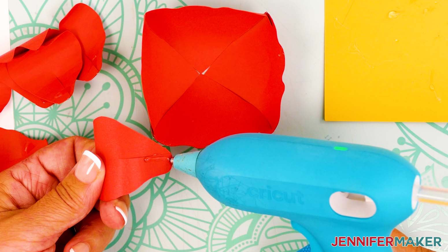 Hold a shaped large inner petal with the curved edge facing away from you and add a dab of hot glue to the tab area.