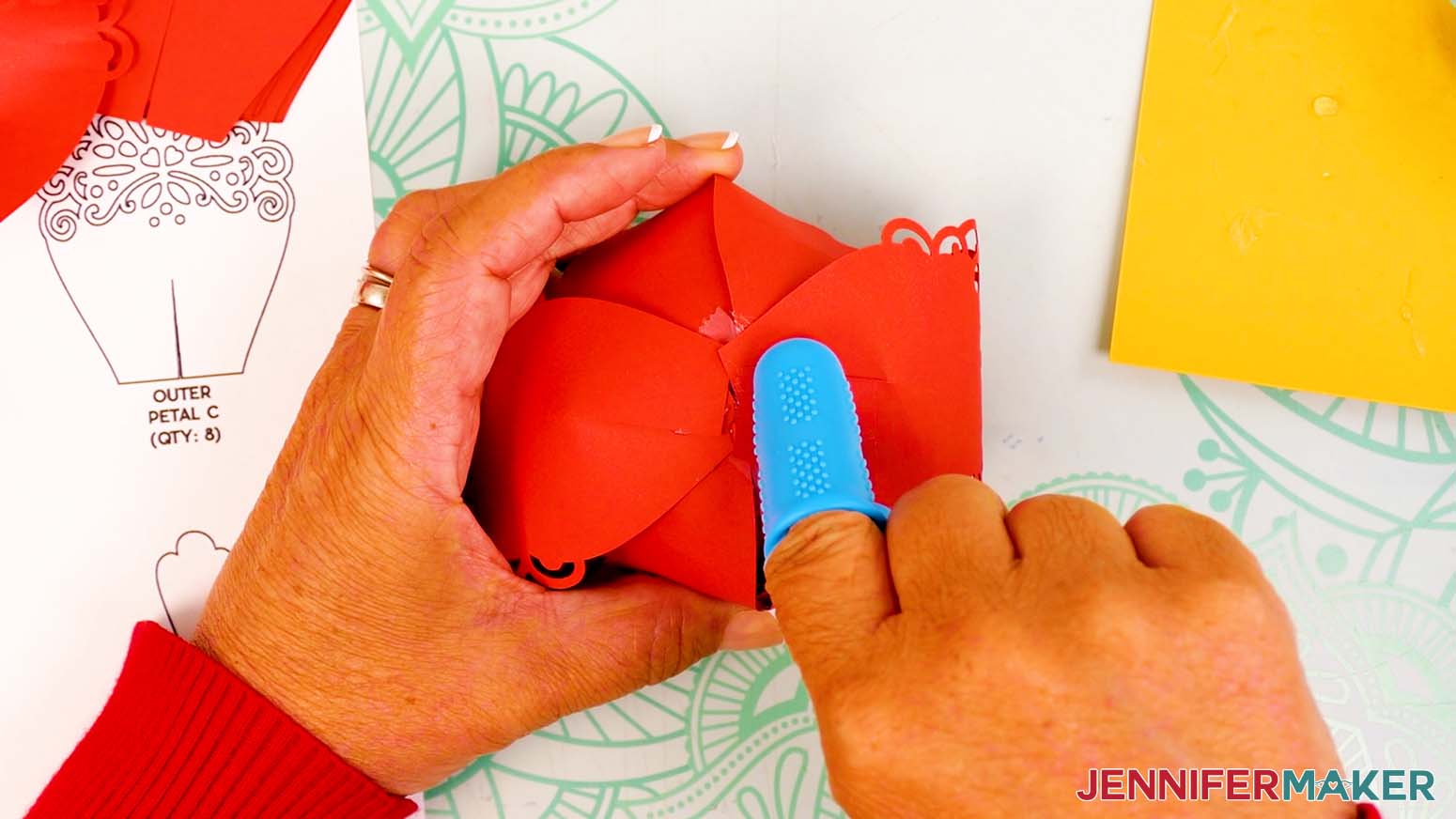 Add hot glue to the tab area of another small outer petal, and adhere it to the opposite outer corner of the bowl.