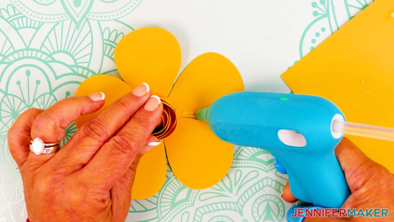 Apply hot glue to the lower right side of the first outer bud petal.