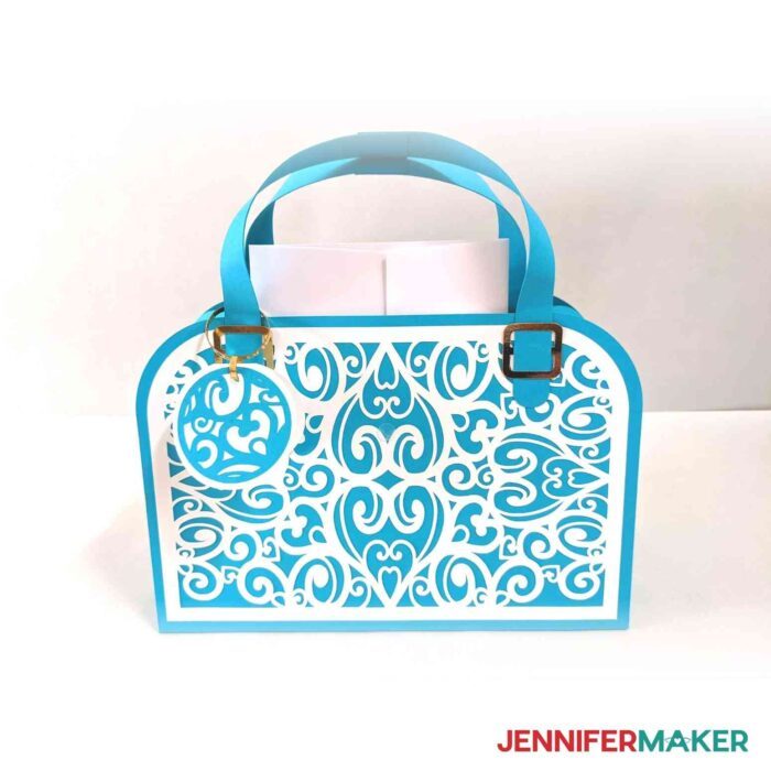 Heartbreaker paper handbag in blue cardstock with white accents holding a full size gift card envelope.