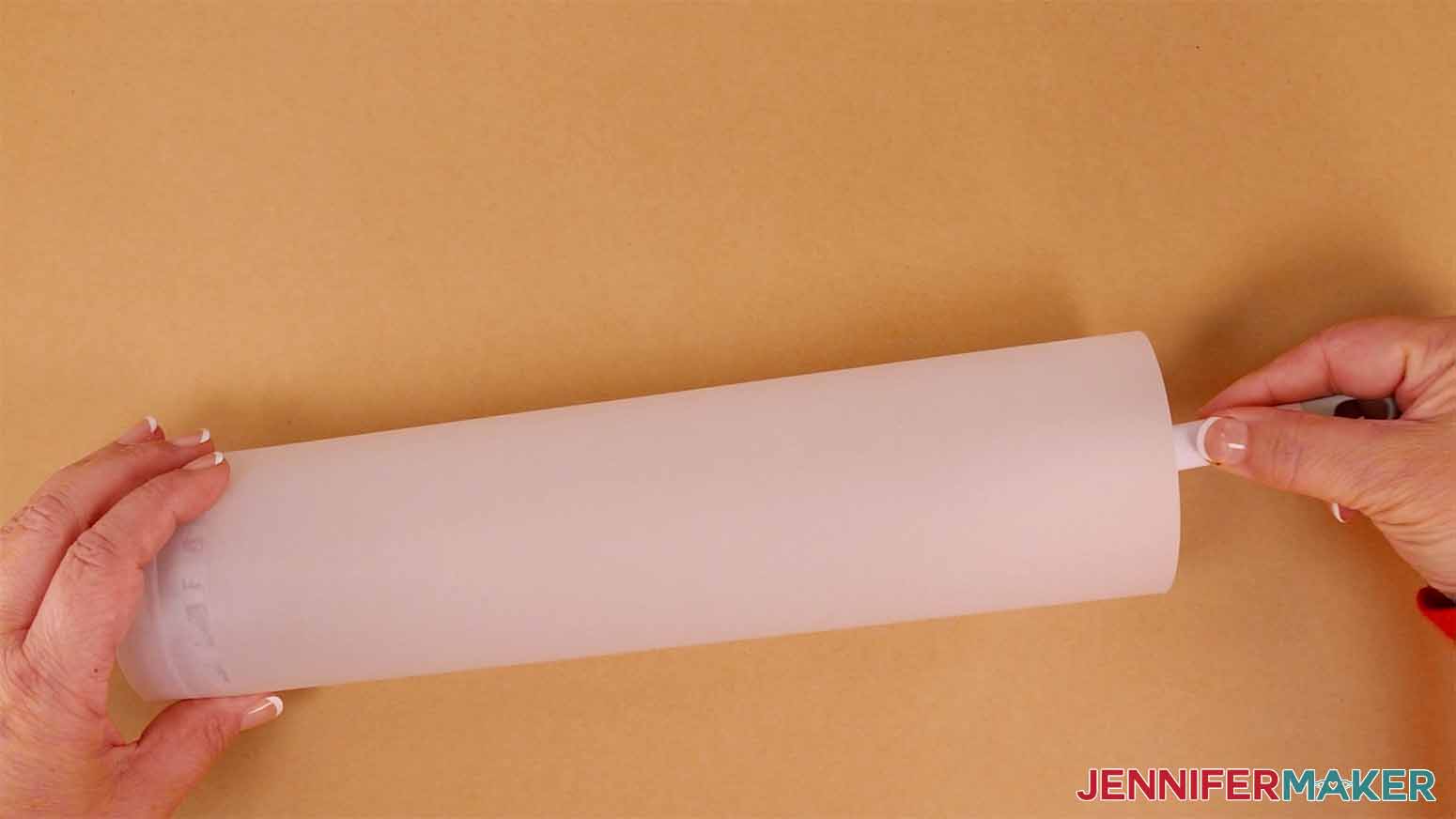 An image of the vellum being taped in a tube shape for the fox variation of the layered paper lanterns with lights.