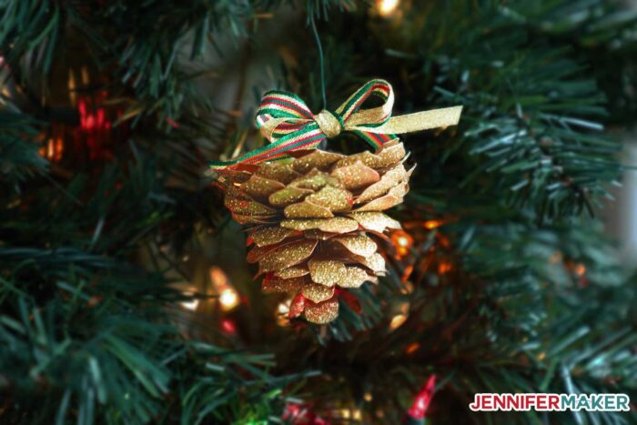 A paper pine cone hanging from a Christmas tree