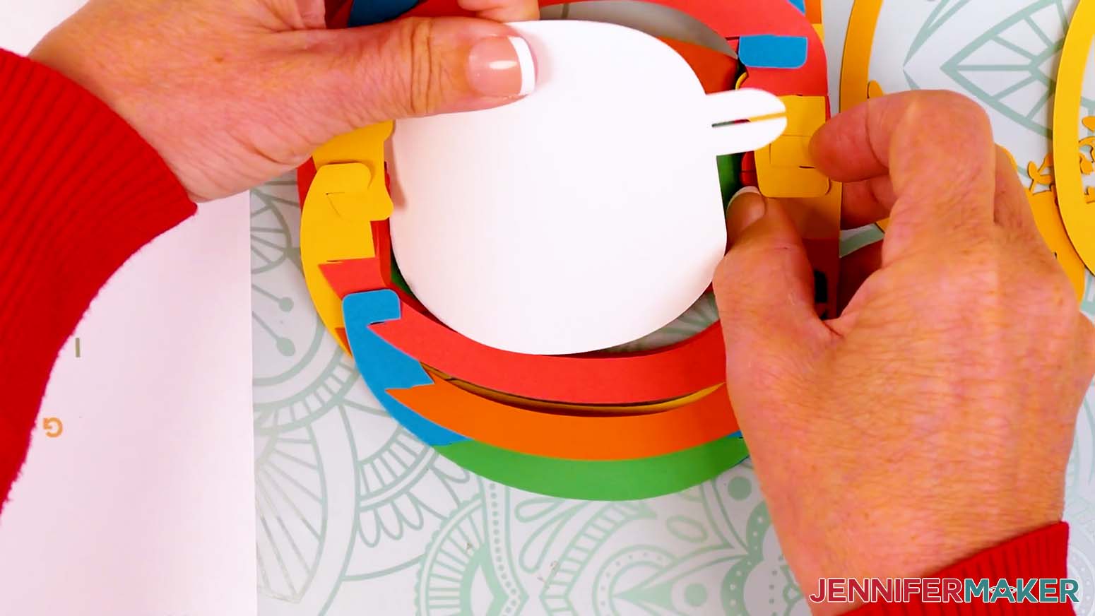 Flip the egg to insert the back scene layer's bottom tab into the bottom bump of the paper pop up Easter egg's shell.