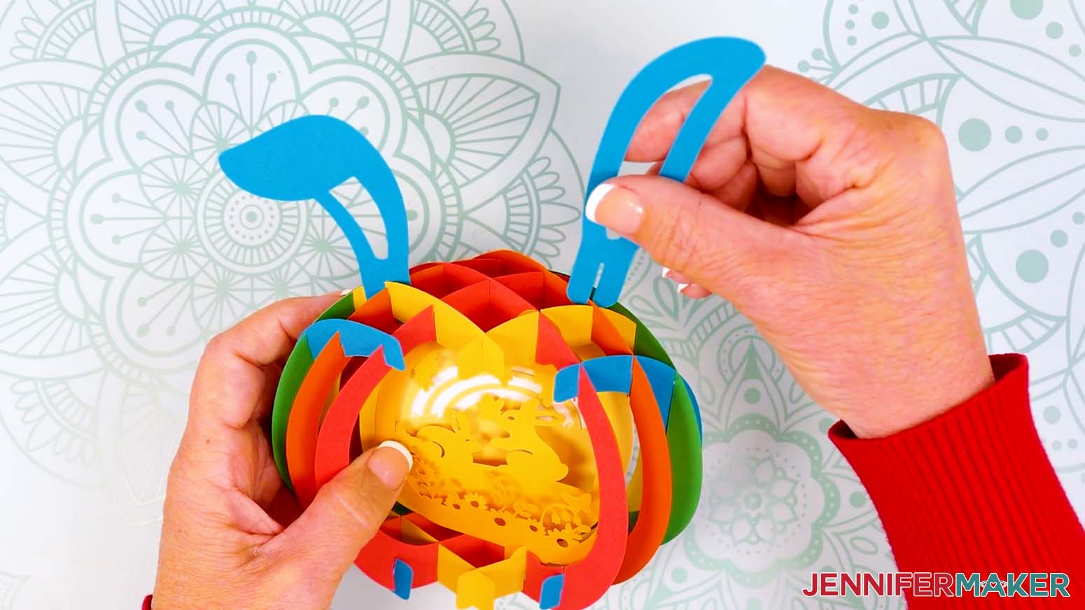 Insert the bunny ear pieces into the top of the assembled paper pop up Easter egg.