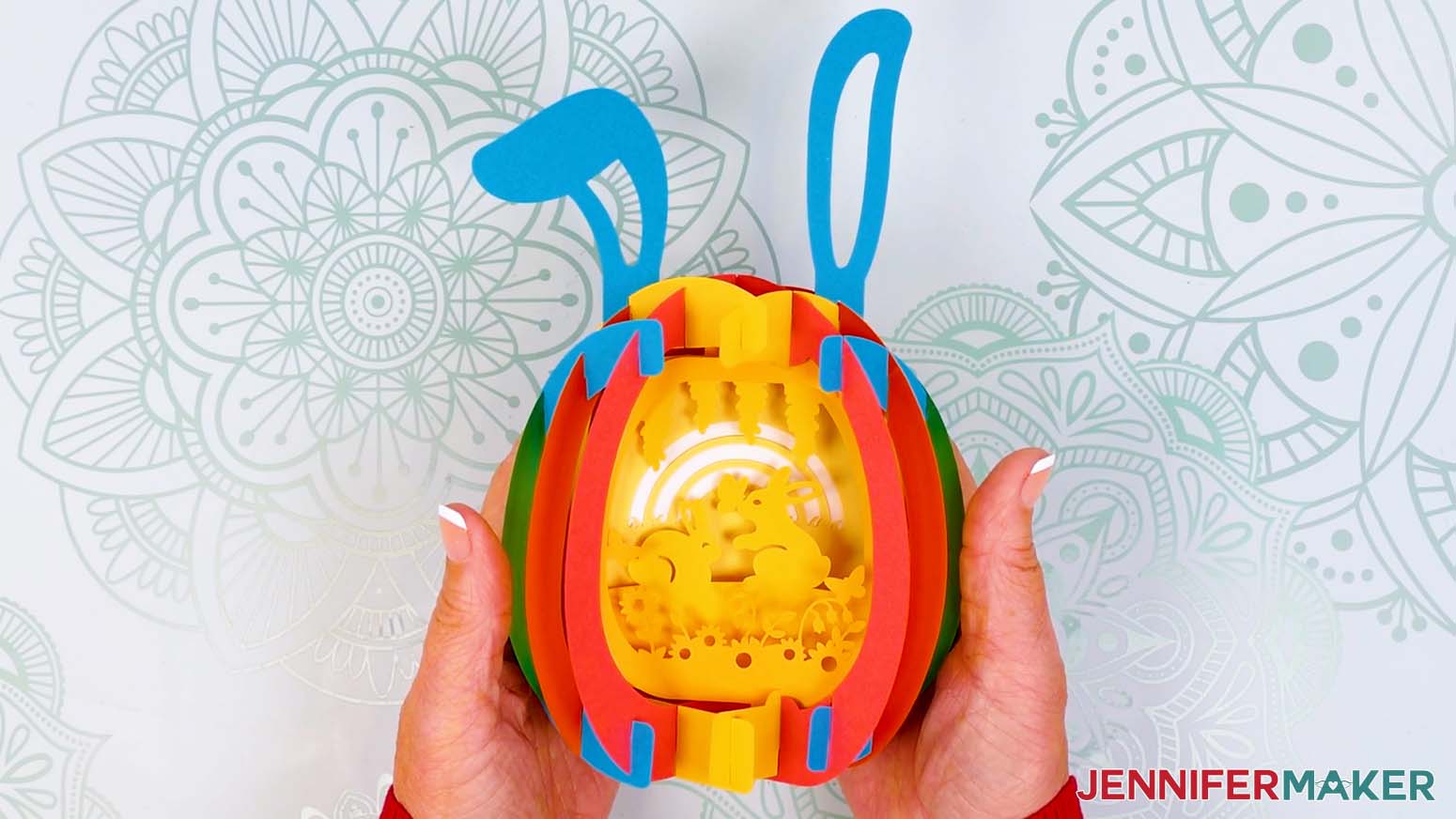 The assembled paper pop up Easter egg with a shell made of rainbow colors and an inner bunny and flower scene.