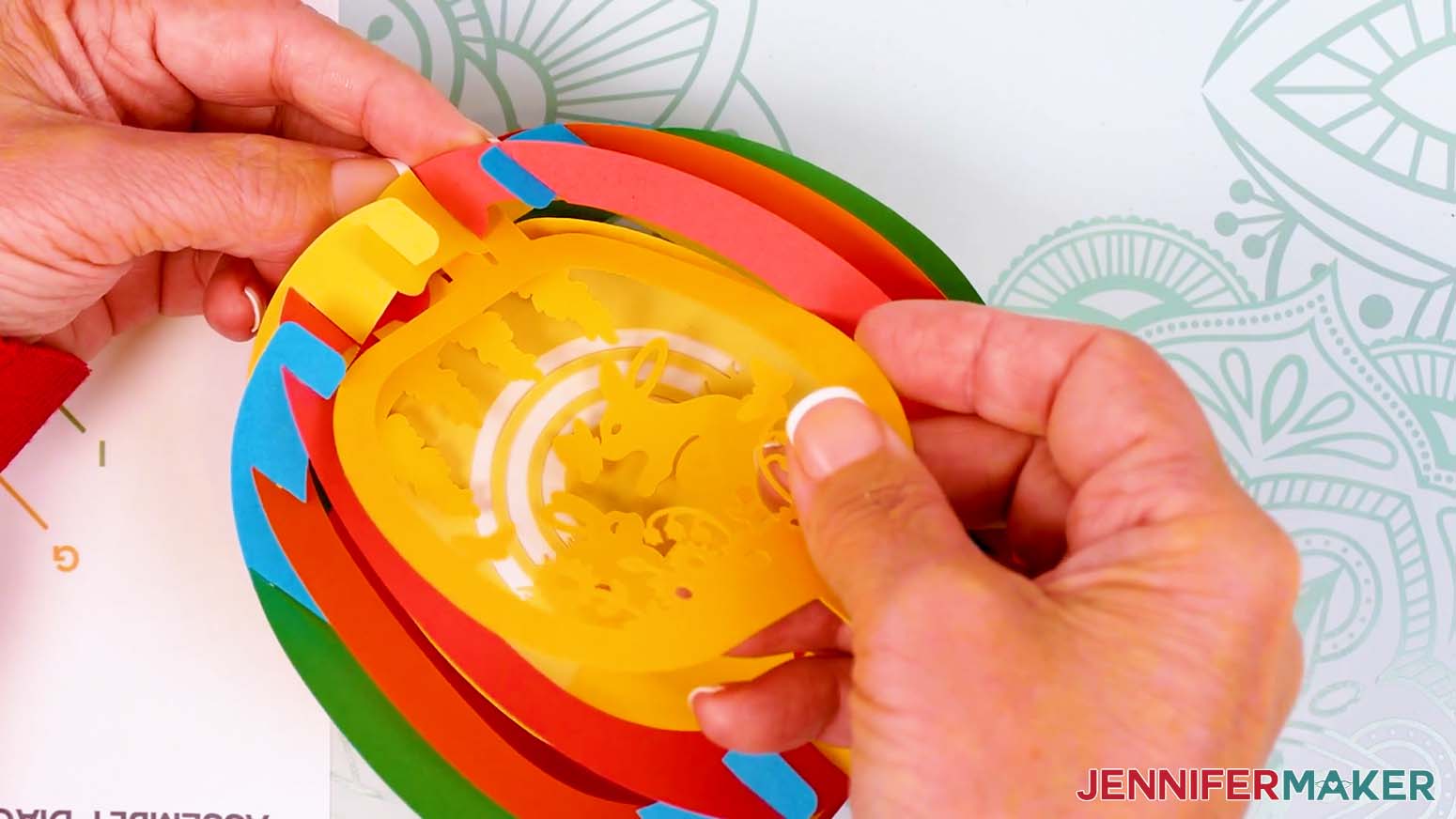 Pinch the front bump from the top outside of the paper pop up Easter egg's shell to insert the front scene layer's tab.