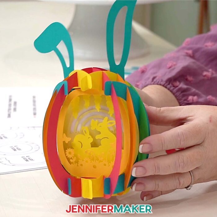 Hands show off a Paper Pop Up Easter Egg project done with colors coordinating with the printable Assembly Diagram