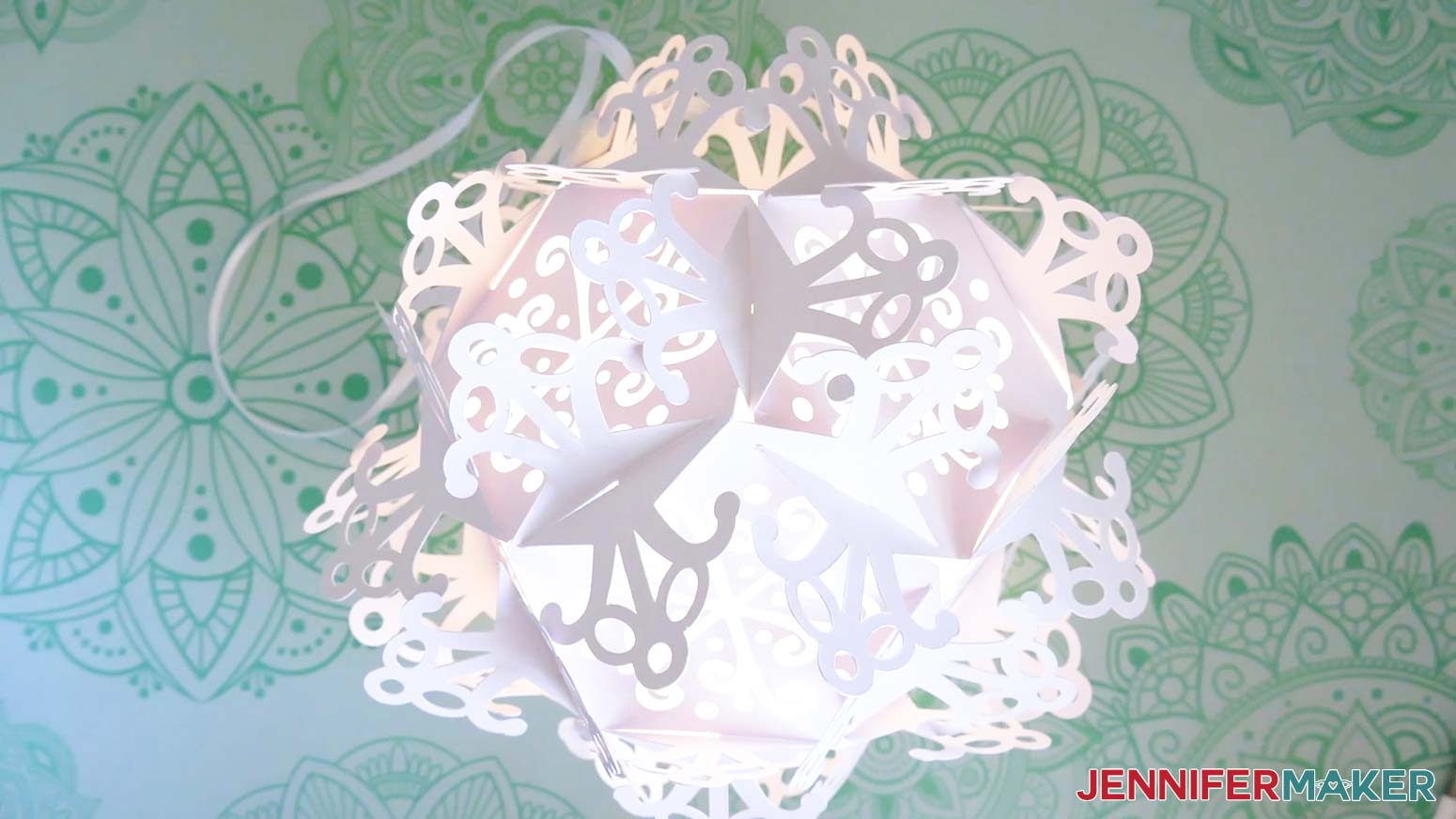 A finished snowflake lantern with a ribbon hanger.