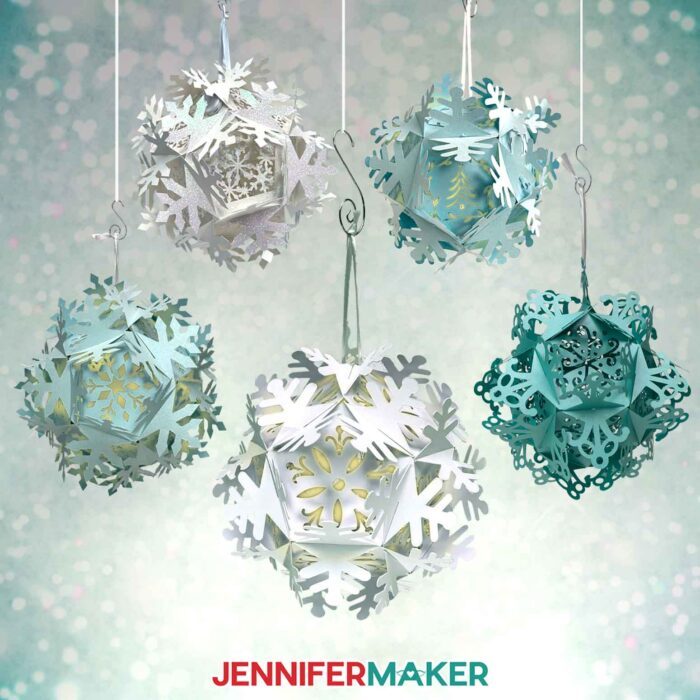 Five blue and white papercut Snowflake Lantern projects hang in a wintry space