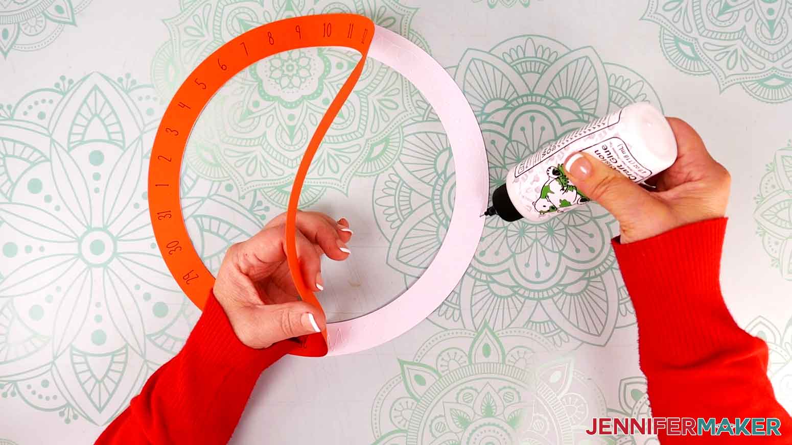 Add glue to the perpetual calendar's large outer wheel in order to attach the cardstock layer on top