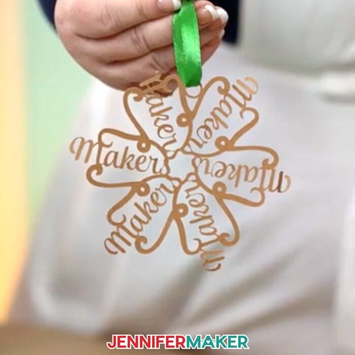 Learn to make a personalized snowflake ornament with your name in JenniferMaker's easy tutorial. Jennifer holds up a name ornament that says "Makers."