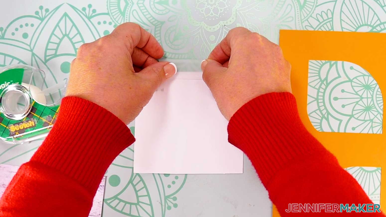 Press the bottom half of the clear tape onto the print, and avoid pressing the top half onto your work surface.