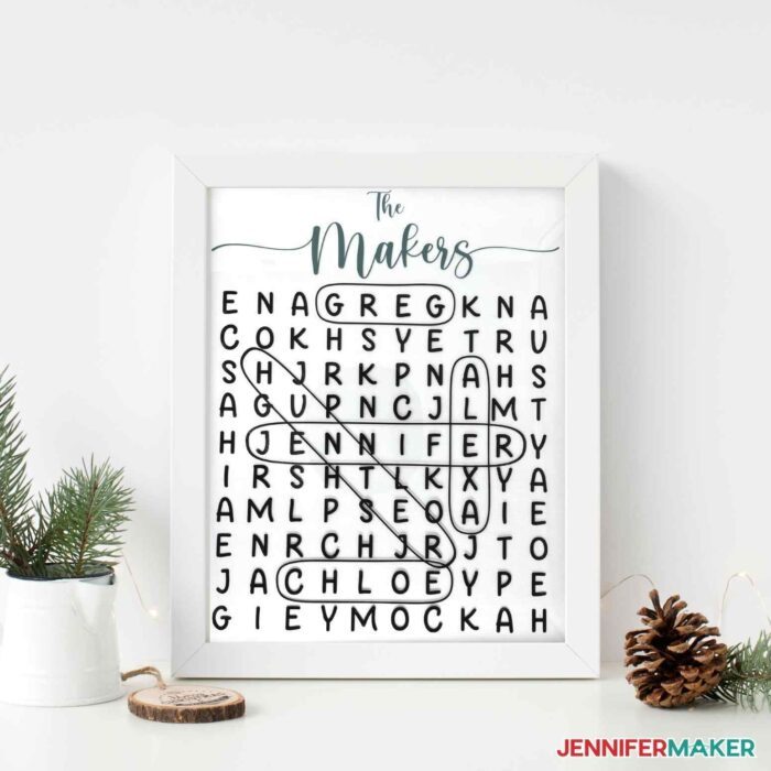 Framed word search next to pine cones and small potted plant on white background