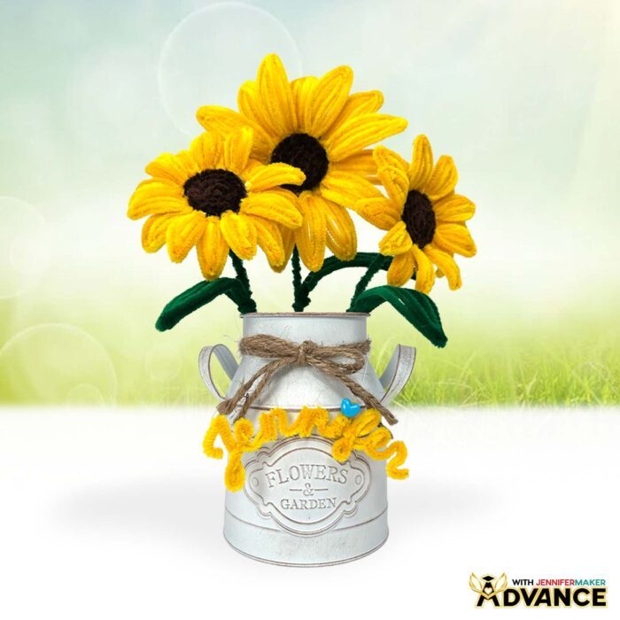 Easy Pipe Cleaner Flowers in a white vase, tied with twine, crafted with yellow pipe cleaners to look like realistic sunflowers. A yellow pipe cleaner name "Jennifer" decorates the vase
