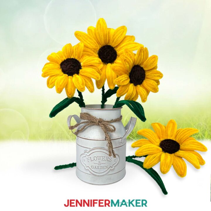 Three pipe cleaner sunflowers displayed in a vase, with an additional pipe cleaner flower lying nearby.