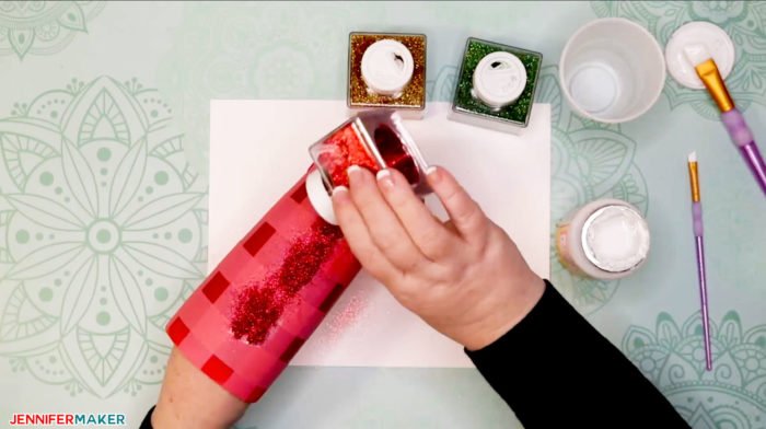 Applying red glitter to a painted and taped tumbler to make a plaid glitter tumbler