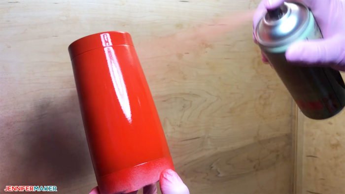 Spray painting a stainless steel tumbler before turning it into a plaid glitter tumbler