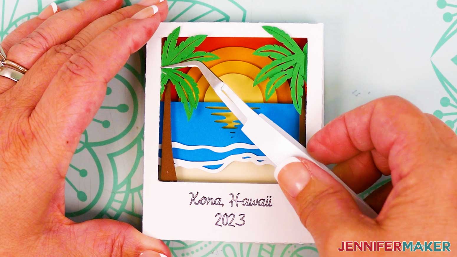 Use tweezers to adhere the additional palm tree frond pieces to the front of the assembled Polaroid Shadow Box.