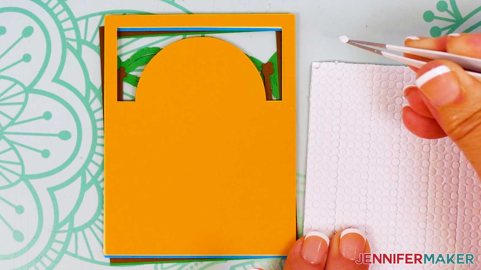 Use tweezers to remove an adhesive micro pop dot from the sheet.