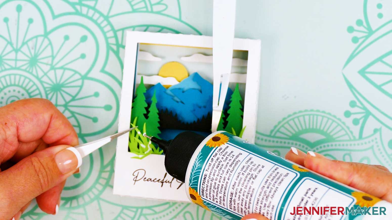 Add dots of craft glue on the back of the extra grass piece to place it on top of the assembled Polaroid Shadow Box mountain scene.
