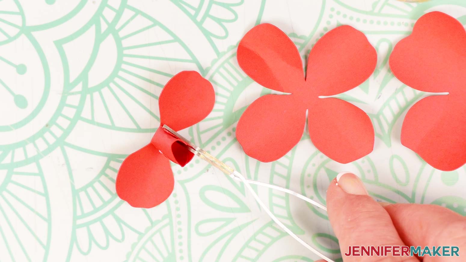 Fold the first two rose petals up toward the center and curl them around each other. Hold them in place until the glue sets.