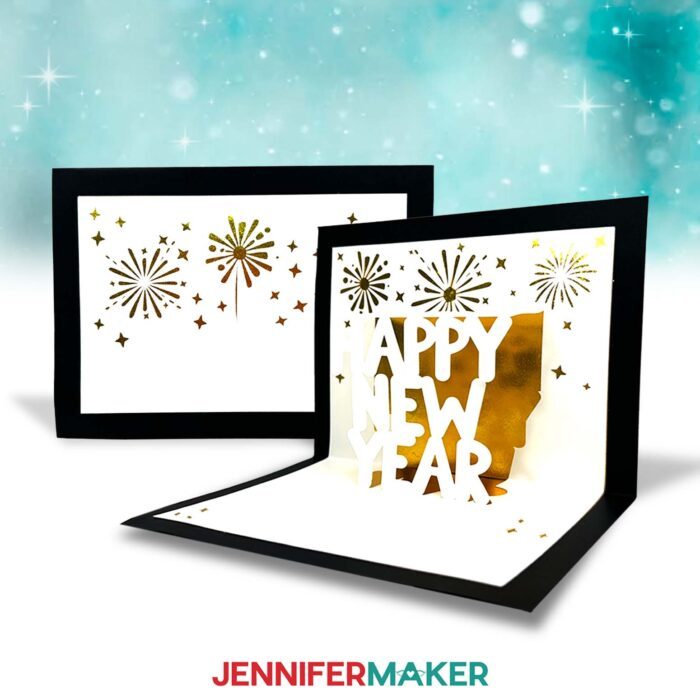 Learn to make a pop up letter card with this tutorial from JenniferMaker! A pop up card is displayed. It has white cardstock on gold foil accent paper with a black background. It says "Happy New Year" in white cardstock beneath gold foil fireworks.