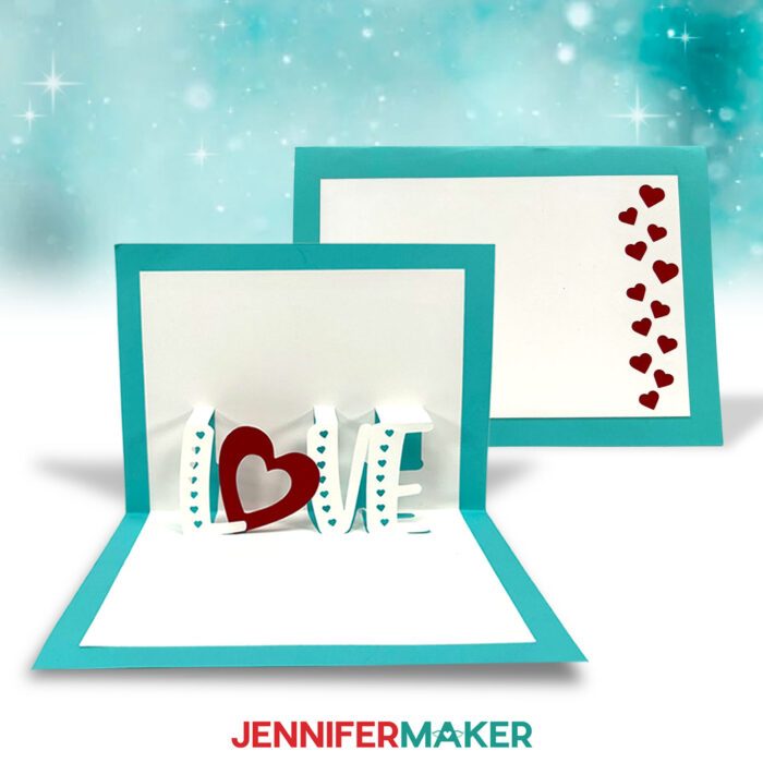 Learn to make a pop up letter card with this tutorial from JenniferMaker! A pop up card is displayed. It has white cardstock on a teal background and says "Love." It has a heart instead of the letter "O." 
