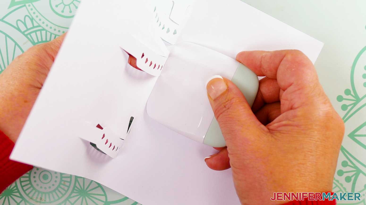A scraper tool helps to fold the letters of the card