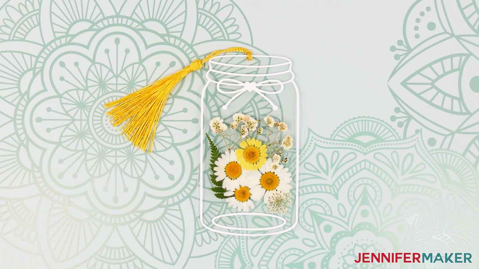 Finished pressed flower bookmark with white and yellow flowers.