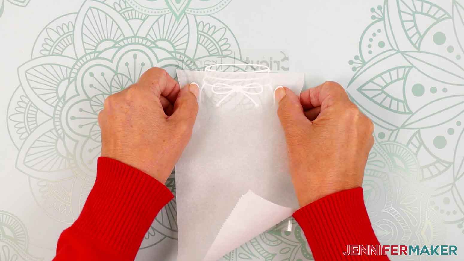Place a piece of parchment paper onto the vinyl and tranfer tape leaving the top exposed.