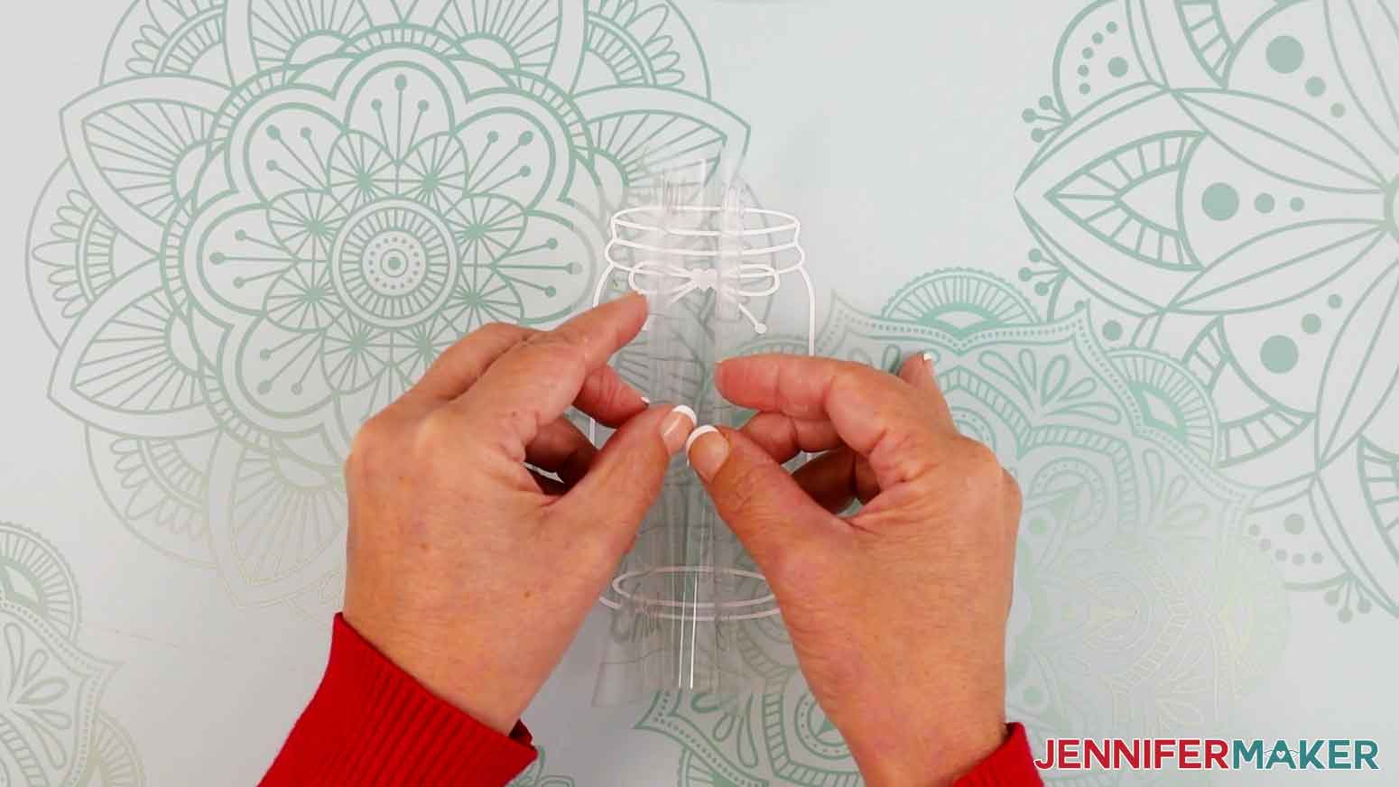 Fold the transfer tape in the shape of a taco and lower the center onto the middle of the vinyl design.