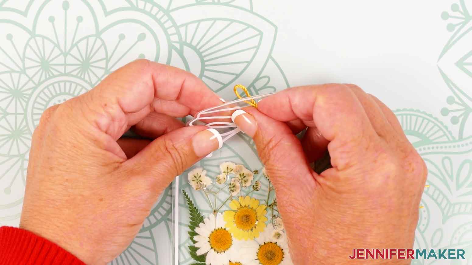 Insert a tassel loop through the hole of the laminated bookmark.