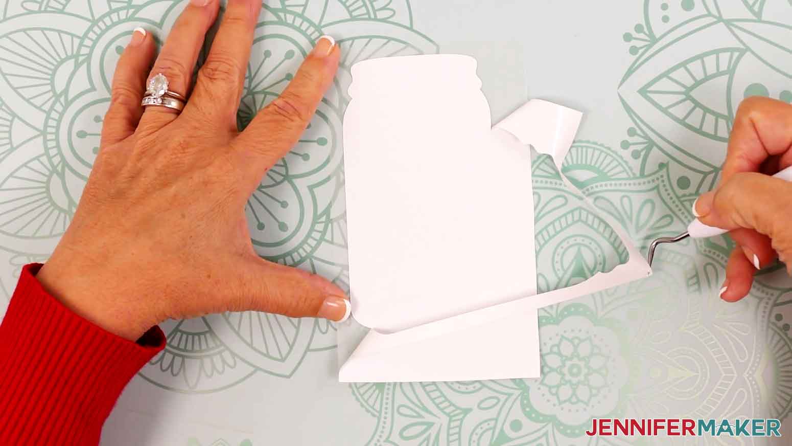 Use a weeding tool to remove the excess vinyl from the pressed bookmark vinyl design.