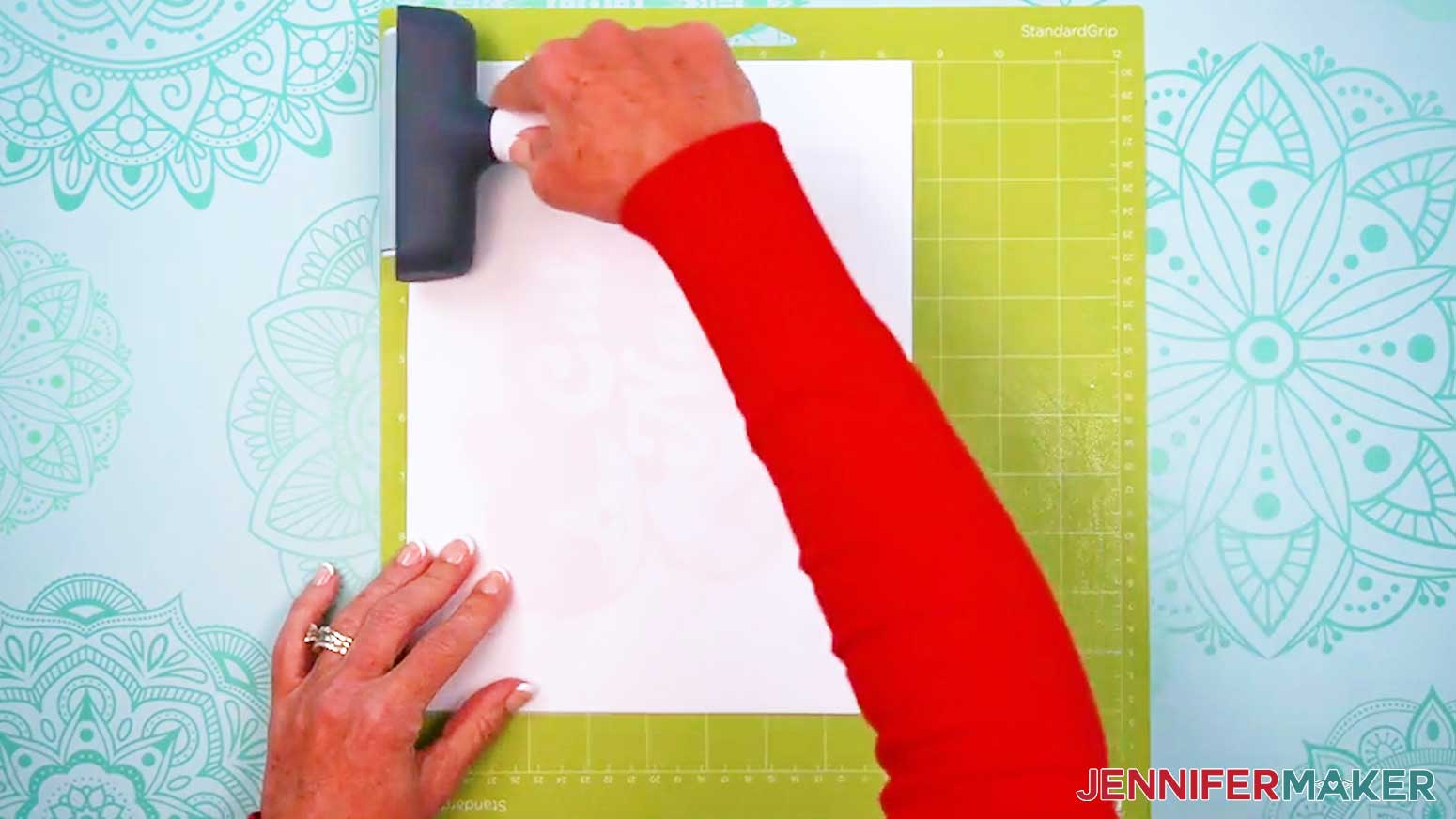 Cover the printable iron-on with a blank piece of paper and use a brayer to fully adhere the material to the mat.
