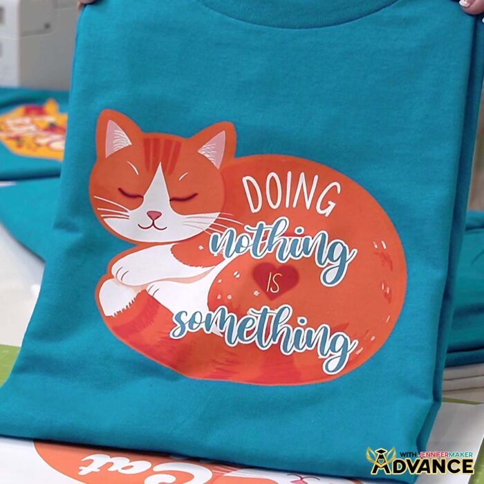 Turquoise T-shirt with a Print Then Cut Iron-On design of a cat with a custom quote "Doing Nothing Is Something"