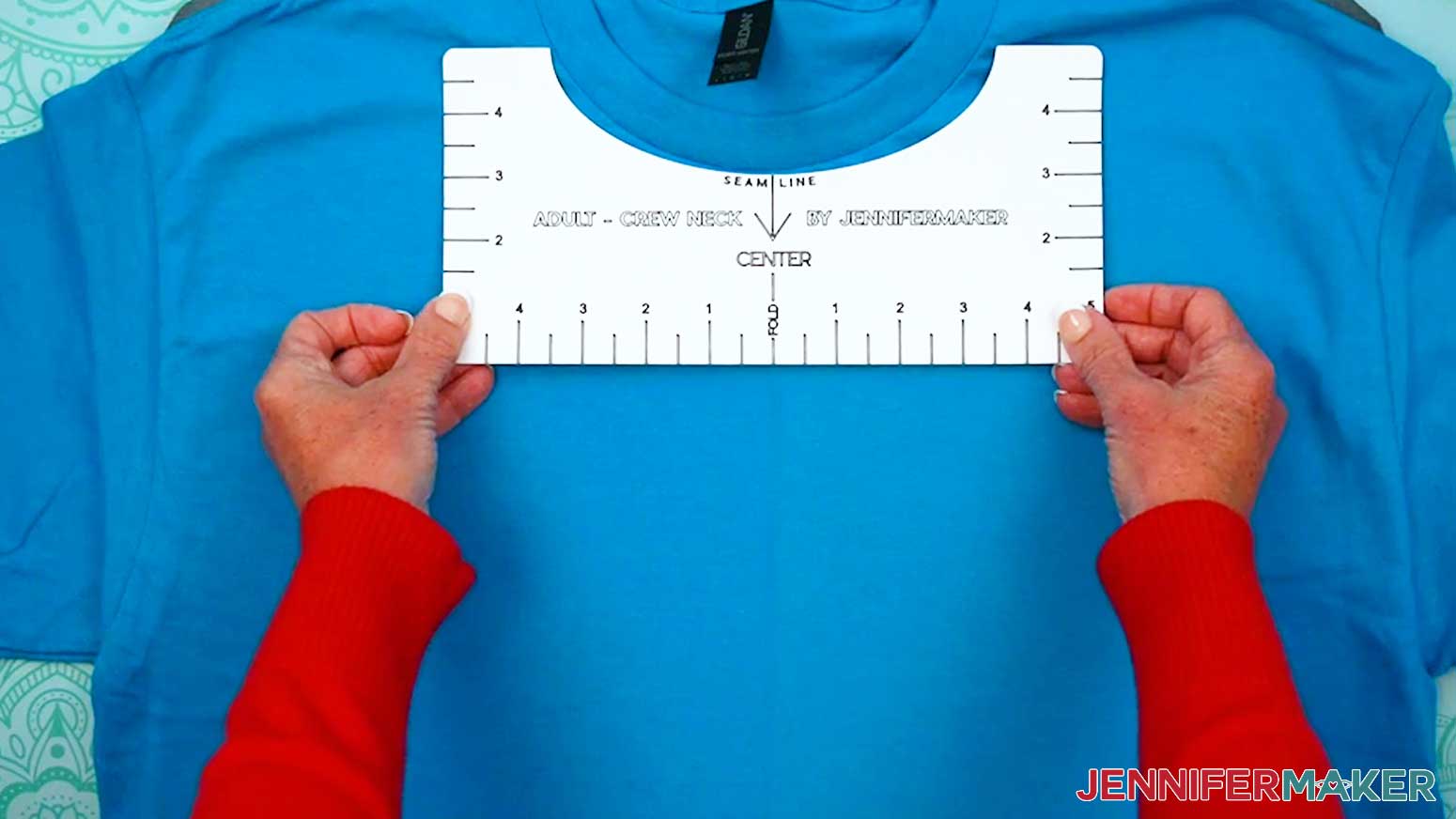 Place the t-shirt guide along the neck seamline and center it with the crease.