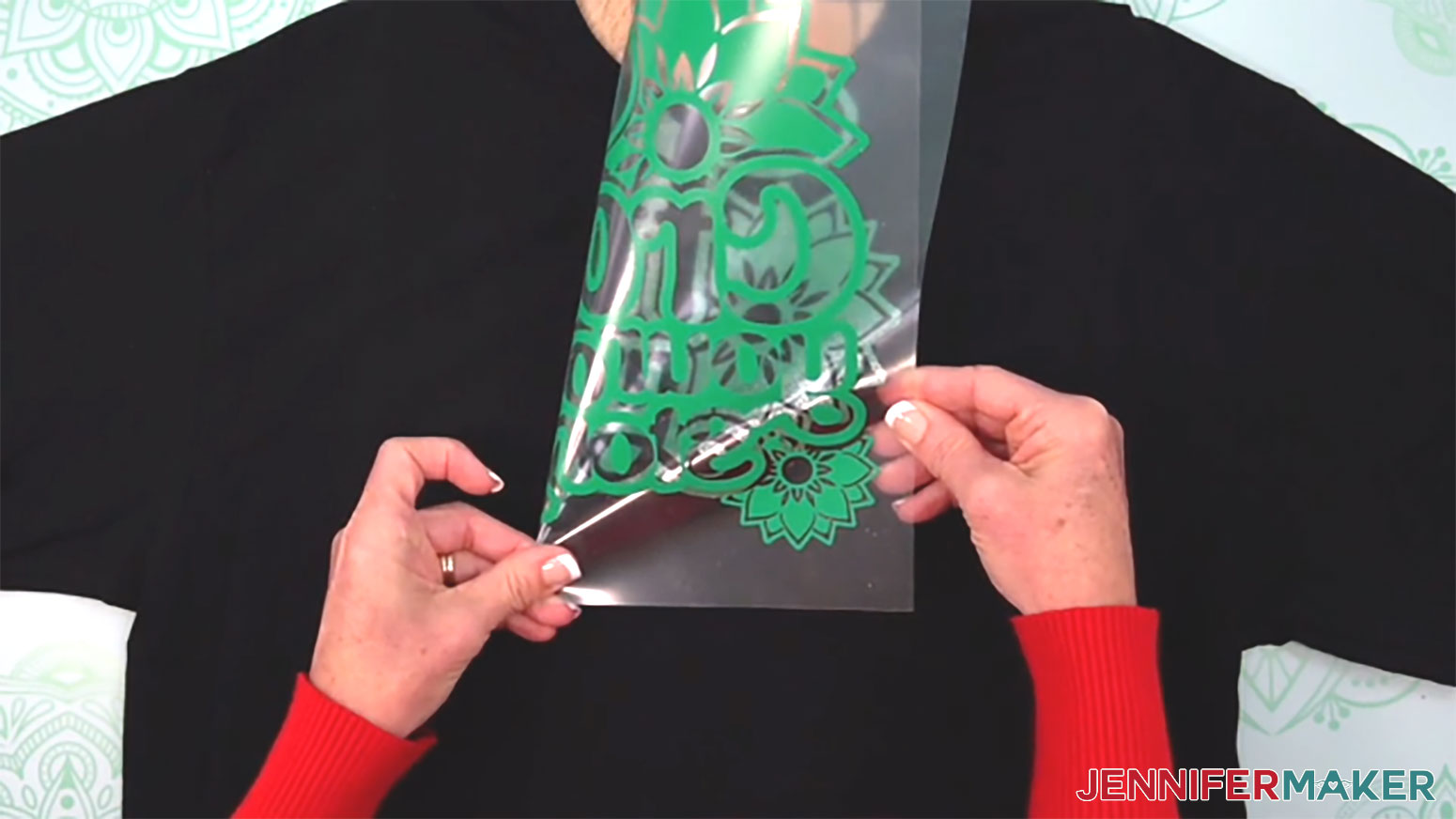Fold the vinyl layer in half and press a small crease at the top and bottom of the carrier sheet to help center the metallic puff vinyl design onto the shirt.