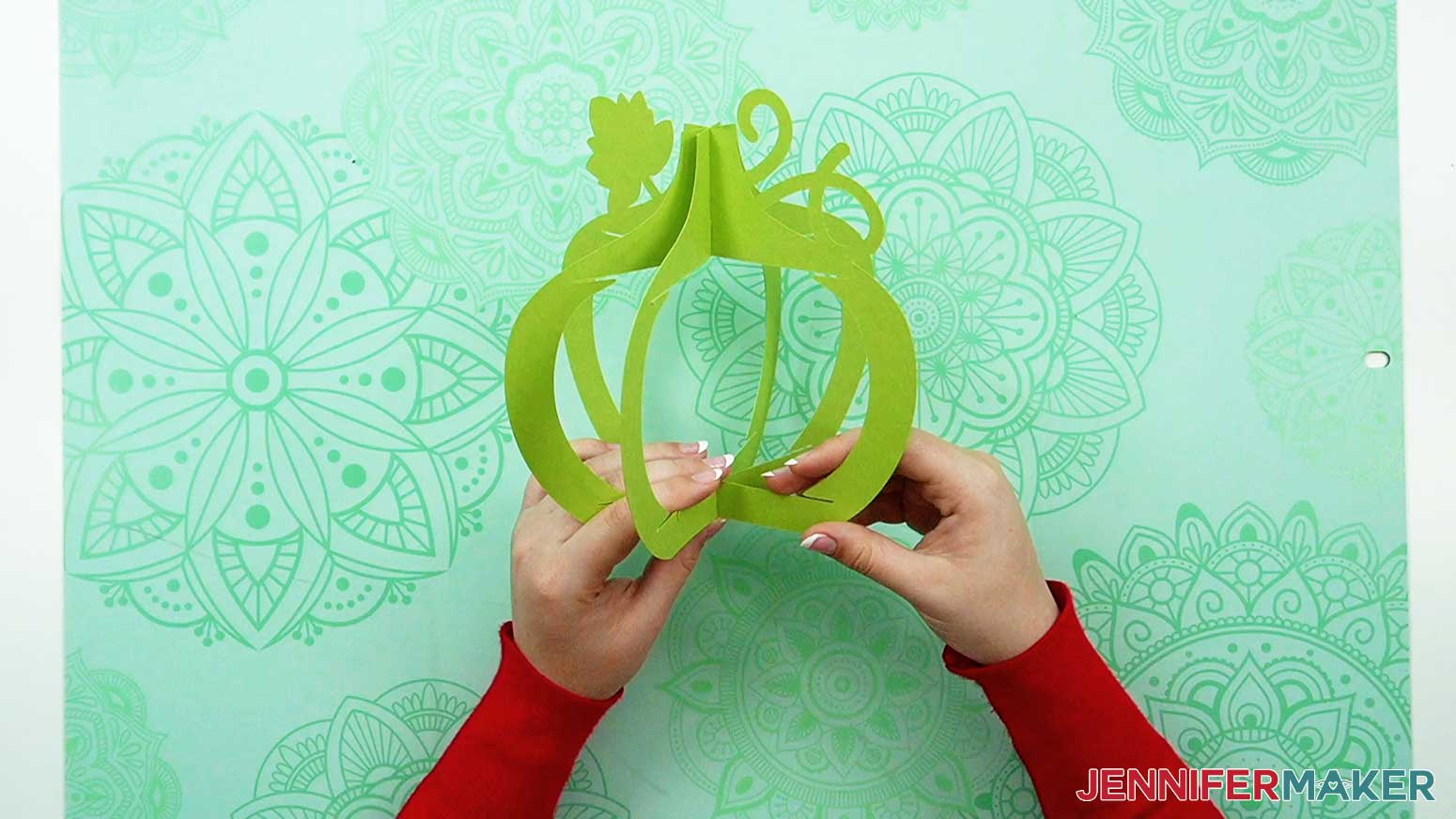 Slot the third green vertical frame with the leaf and vine into the first two frame pieces for the 3D pumpkin lantern