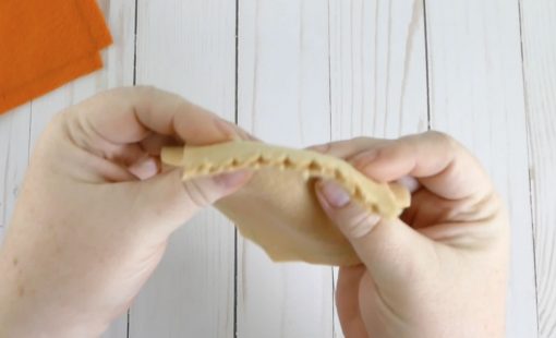 Fold over the crust to create the edge for the pumpkin pie plushie