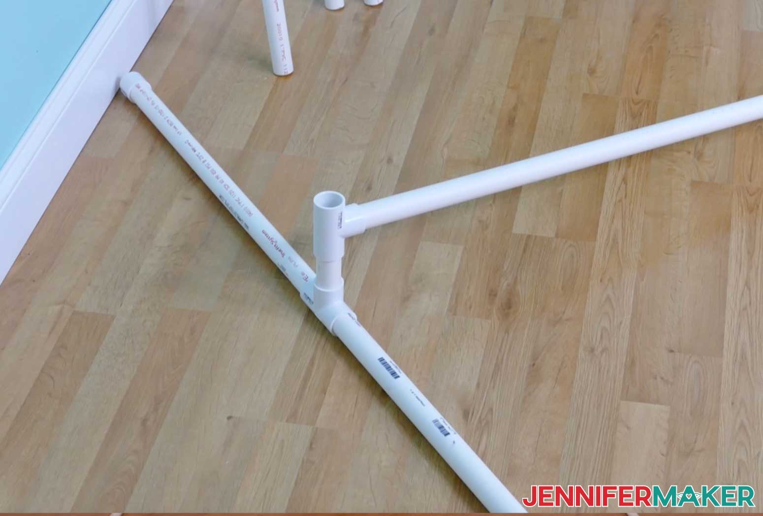 A 92" long PVC pipe inserted into a Tee connector to form a DIY backdrop stand