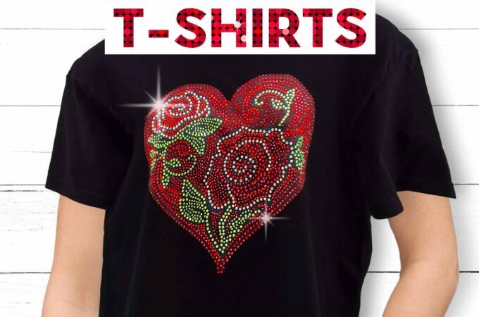 Person standing against a white background wearing a black t-shirt with a dazzling rhinestone heart design done in red, green, and clear rhinestones. Learn how to make rhinestone t-shirts using your Cricut cutting machine with JenniferMaker's tutorial!