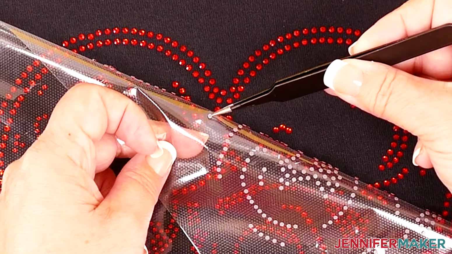 Remove the guide rhinestones from the heat transfer material before heat pressing the layer onto the cloth.