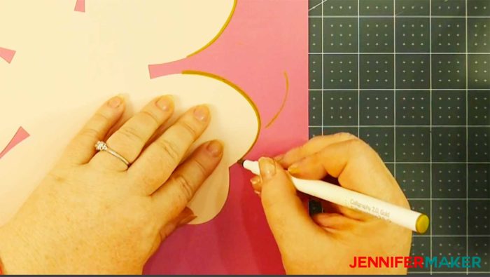 Coloring the edges of the paper petals with gold marker to make a rose gold paper flower