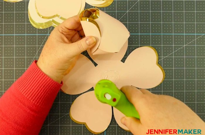 Gluing the paper petals onto a giant rose gold paper flower