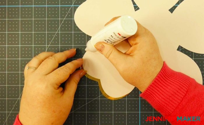 Gluing gold foil to the edge of paper petal to make a rose gold paper flower