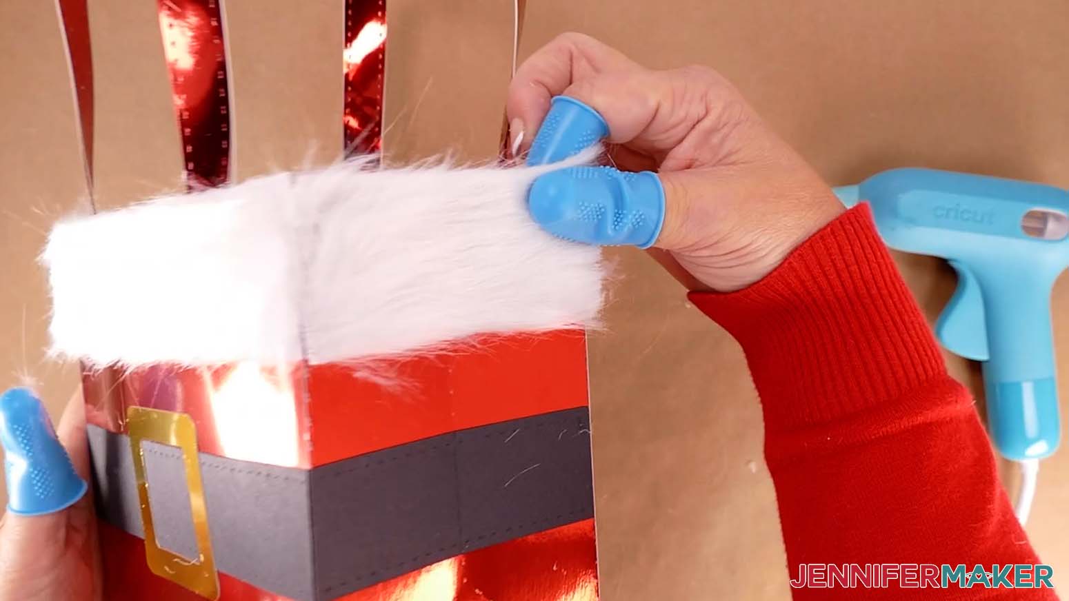 Adhere a short strip of faux fur to the Santa purse&rsquo;s side using hot glue.